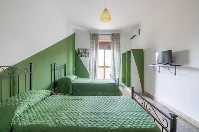 two beds in a room with green walls at Three large bedrooms for six people Rome downtown apartment in Rome