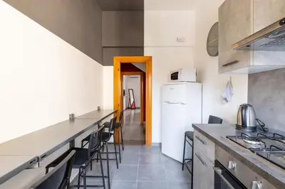 a kitchen with a counter and some chairs in it at Three large bedrooms for six people Rome downtown apartment in Rome