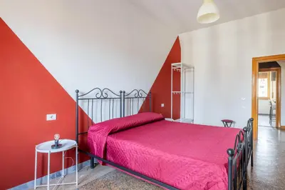a red and white bedroom with a bed and a table at Three large bedrooms for six people Rome downtown apartment in Rome