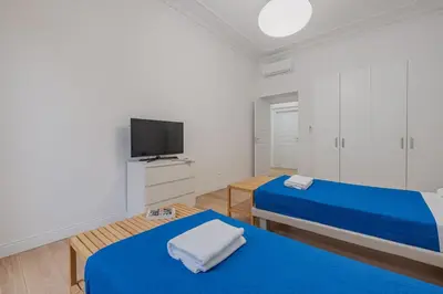 a white room with two beds and a flat screen tv at Life Home Vatican in Rome
