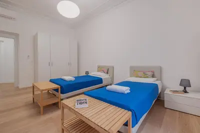 a room with two beds and a table in it at Life Home Vatican in Rome