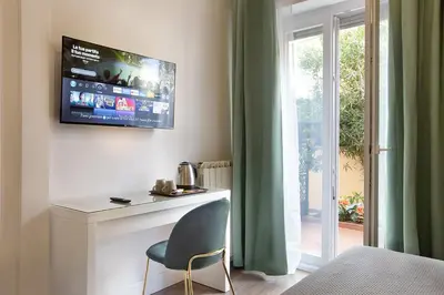 a room with a chair and a television on a wall at Charme Holidays Puccini in Rome