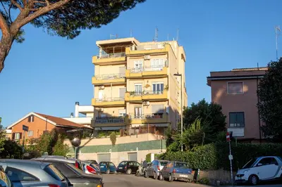 a tall yellow building with cars parked in front of it at Charme Holidays Puccini in Rome