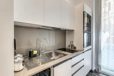 a kitchen with white cabinets and a sink at Clodio Guest House in Rome