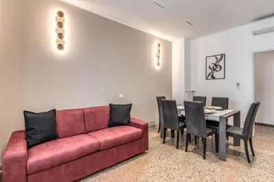 a living room with a red couch and a table at Clodio Guest House in Rome
