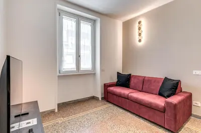 a living room with a red couch and a tv at Clodio Guest House in Rome