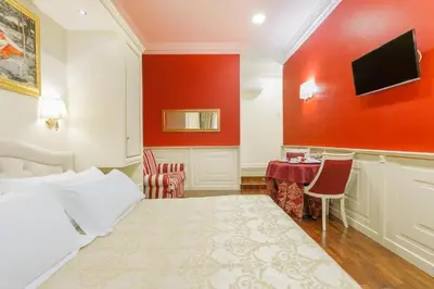 a hotel room with a bed and a table with chairs at Dimora Frattina in Rome