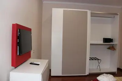 a living room with a tv and a white cabinet at Dimora Frattina in Rome