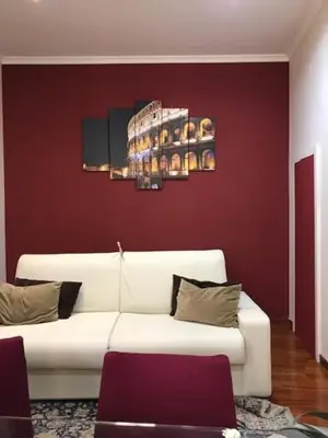 a living room with a white couch and a red wall at Dimora Frattina in Rome
