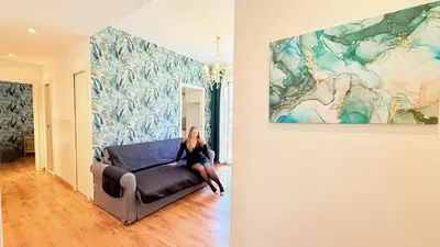 a woman sitting on a couch in a room with a painting at Dimora Frattina in Rome