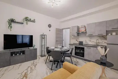 a living room with a table and a kitchen at Petit House Roma in Rome