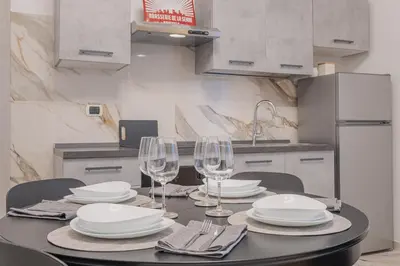 a dining room table with plates and wine glasses at Petit House Roma in Rome