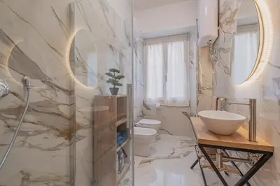 a bathroom with two toilets and a sink and a mirror at Petit House Roma in Rome
