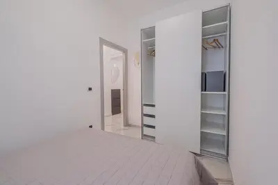 a white room with a bed and a closet at Petit House Roma in Rome