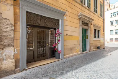 a building with a large wooden door with flowers on it at Trasteverina Apartment in Rome