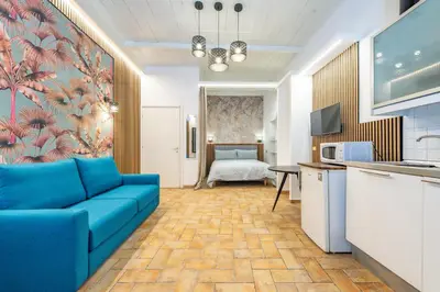 a living room with a blue couch and a bedroom at Trasteverina Apartment in Rome