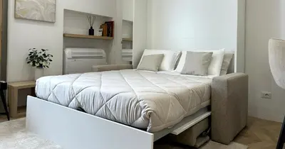 a bedroom with a large bed with white sheets and pillows at YCH-Vatican Superior Suite in Rome