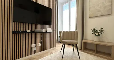 a living room with a chair and a television on a wall at YCH-Vatican Superior Suite in Rome