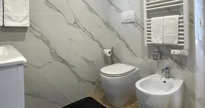 a white bathroom with a toilet and a sink at YCH-Vatican Superior Suite in Rome