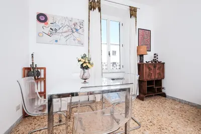 a dining room with a glass table and chairs at Linda Apartment in Rome