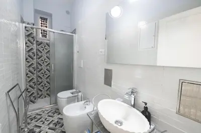 a white bathroom with a sink and a toilet at Linda Apartment in Rome