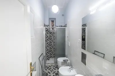 a white bathroom with a toilet and a sink at Linda Apartment in Rome