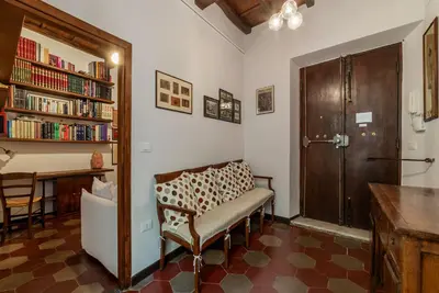 a living room with a chair and a book shelf at GuestHost - Stylish Apartment in the Heart of Rome in Rome