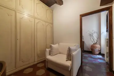 a living room with a chair and a mirror at GuestHost - Stylish Apartment in the Heart of Rome in Rome