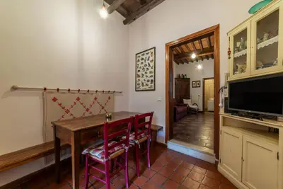 a dining room with a table and chairs and a television at GuestHost - Stylish Apartment in the Heart of Rome in Rome