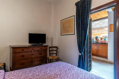 a bedroom with a bed and a dresser with a television at GuestHost - Stylish Apartment in the Heart of Rome in Rome