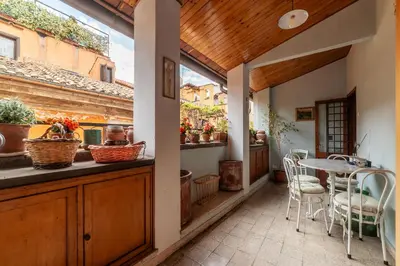 a patio with a table and chairs in a house at GuestHost - Stylish Apartment in the Heart of Rome in Rome