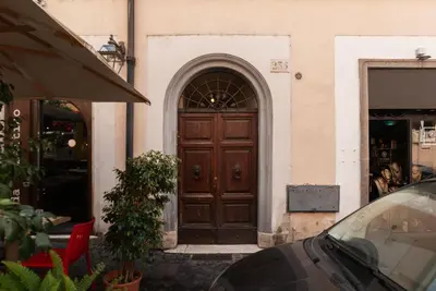 a door to a building with a car parked in front at GuestHost - Stylish Apartment in the Heart of Rome in Rome
