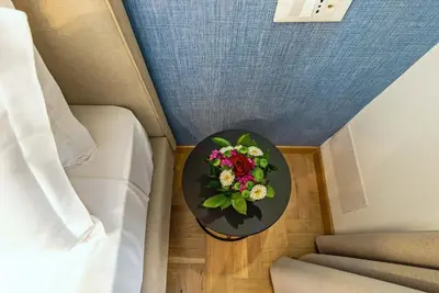 a table with flowers on it next to a bed at Essence Collection Hotel in Rome