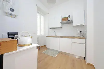a white kitchen with white cabinets and a sink at Makà 32 in Rome
