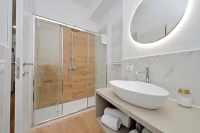 a white bathroom with a sink and a shower at Makà 32 in Rome