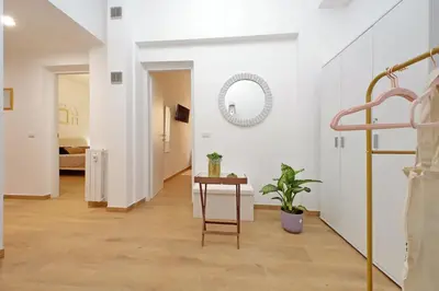 a hallway with white walls and a table and a mirror at Makà 32 in Rome