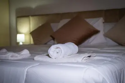 a pile of towels on a white bed at Trevi Room in Rome