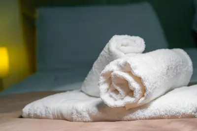a pile of white towels sitting on a bed at Trevi Room in Rome