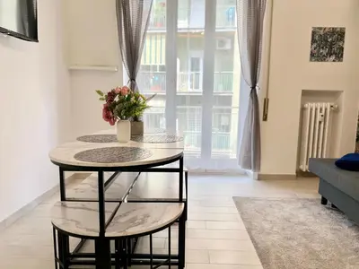 a table with a vase of flowers on it in a living room at Stylish Apartment near Trastevere in Rome