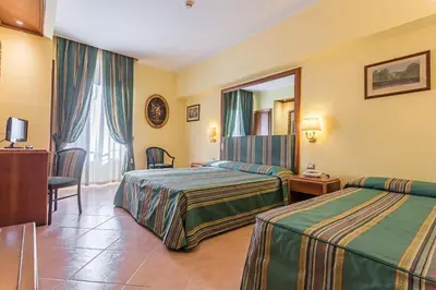 a hotel room with two beds and a mirror at Raeli Hotel Noto in Rome