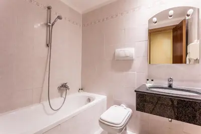 a bathroom with a toilet and a sink and a bath tub at Raeli Hotel Noto in Rome