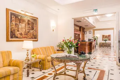 a lobby with a table and chairs and a piano at Raeli Hotel Noto in Rome