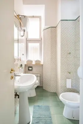 a white bathroom with a sink and a toilet at Nido degli Artisti in Trastevere Piazza Trilussa in Rome