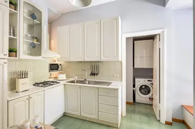 a kitchen with white cabinets and a sink at Nido degli Artisti in Trastevere Piazza Trilussa in Rome