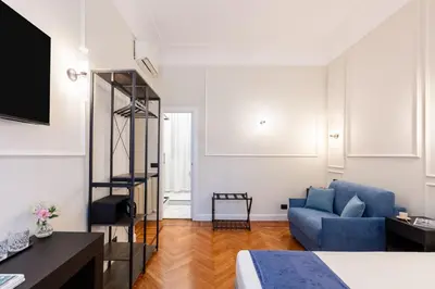 a room with a bed and a blue couch at Piazza del Popolo Boutique GuestHouse in Rome