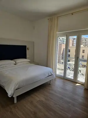 a bedroom with a large bed and a balcony at Toto San Paolo Rooms in Rome
