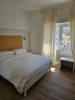 a bedroom with a large white bed and a window at Toto San Paolo Rooms in Rome