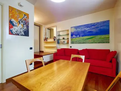 a living room with a red couch and a wooden table at Sweet Home Colosseum in Rome