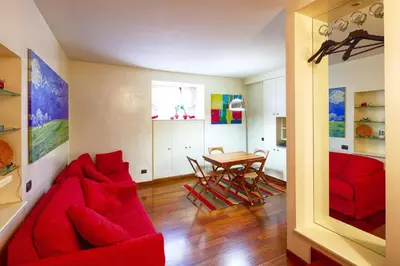 a living room with a red couch and a table at Sweet Home Colosseum in Rome
