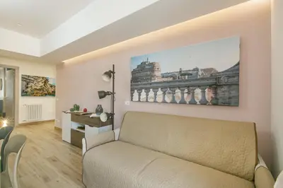 a living room with a couch and a painting on the wall at Roma Vaticano Deluxe in Rome